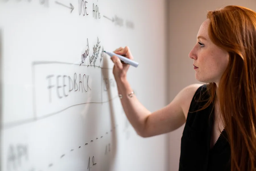 An engineer working through an architecture diagram at a whiteboard