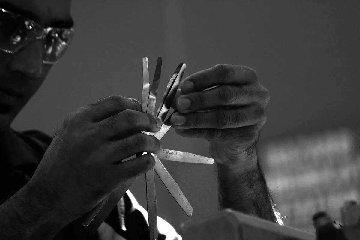 A technician inspecting a vehicle with hand tools