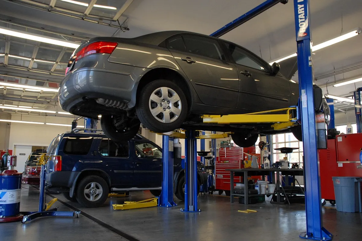 Vehicles on hoists across a multi-bay workshop